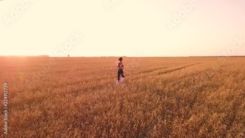 Young girl runner in wheat field photo