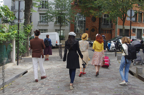 Fototapeta Naklejka Na Ścianę i Meble -  Group of tourists in the cobbled streets of Montmartre in Paris with the house facades in the background