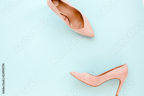 Pastel pink women high heel shoes on blue background. Flat lay, top view trendy fashion feminine background. Beauty blog concept. Fashion blog look. 