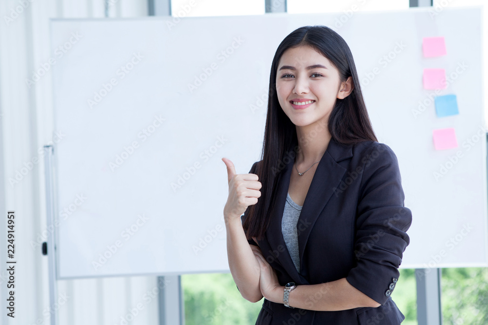 Happy smiling beautiful young asian business woman show thumbs up isolated on White board background in office.entrepreneur girl in work place meeting room looking at camera Happy smiling beautiful young asian business woman show thumbs up isolated on White board background in office.entrepreneur girl in work place meeting room looking at camera