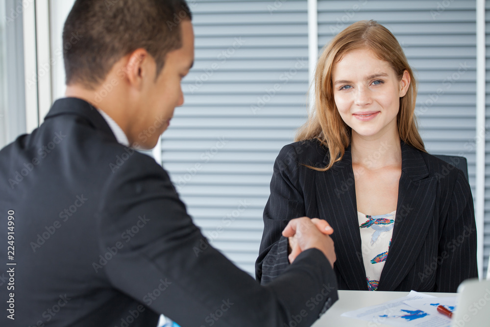 business woman shaking hands with businessman in office . girl looking at camera business woman shaking hands with businessman in office . girl looking at camera