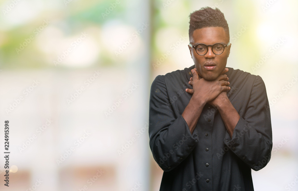 Young african american priest man over isolated background shouting and suffocate because painful strangle. Health problem. Asphyxiate and suicide concept. Young african american priest man over isolated background shouting and suffocate because painful strangle. Health problem. Asphyxiate and suicide concept.
