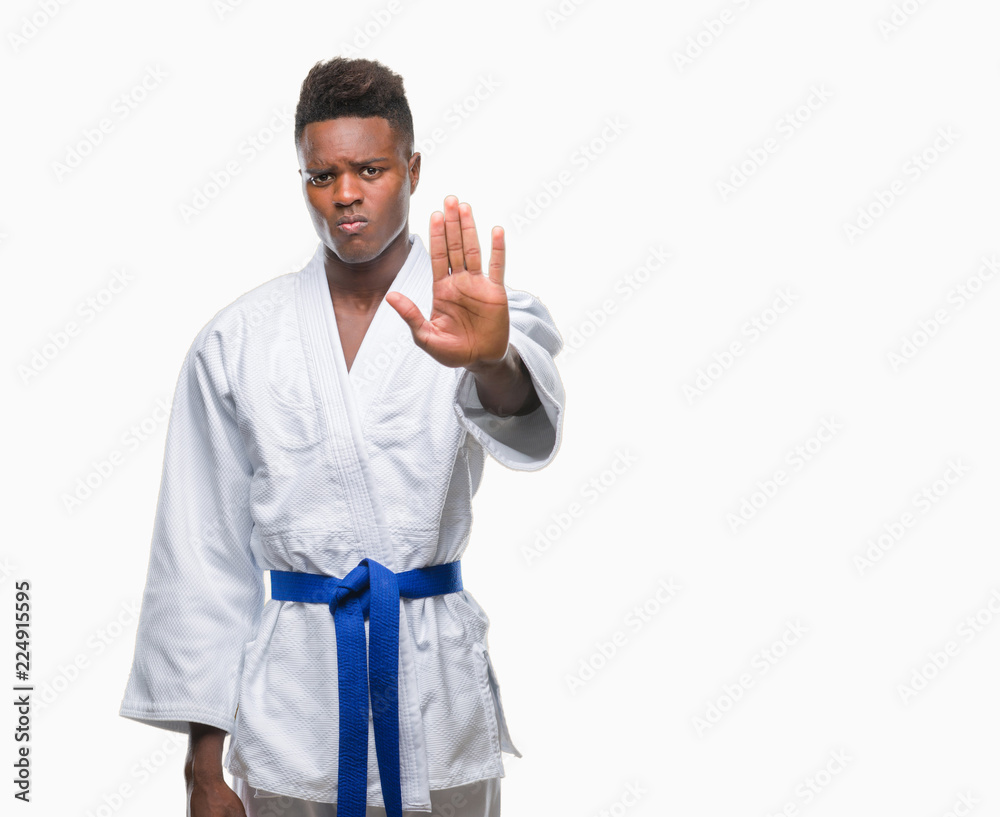 Young african american man over isolated background wearing kimono doing stop sing with palm of the hand. Warning expression with negative and serious gesture on the face. Young african american man over isolated background wearing kimono doing stop sing with palm of the hand. Warning expression with negative and serious gesture on the face.