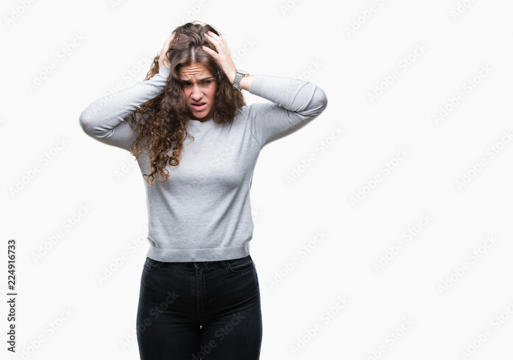 Beautiful brunette curly hair young girl wearing a sweater over isolated background suffering from headache desperate and stressed because pain and migraine. Hands on head.