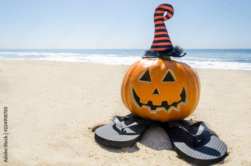 Obraz premium Beach Halloween background with pumpkin in the witch's hats