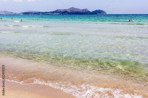 Summer beach with emerald crystal clear water and sand cakes left on the white sand beach. Playa de Muro, Mallorca, Balearic islands, Spain.