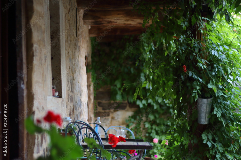 Terraza de una casa rural antigua de pueblo. Con mesas para descansar y ...