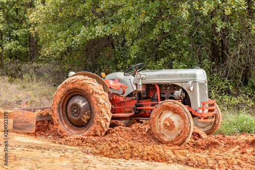 Slika na platnu Old workhorse tractor scraping mud.