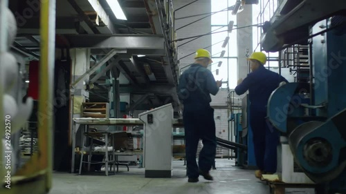 Wallpaper Mural Tracking shot of two engineers, man and woman, walking through industrial facility and discussing work, rear view Torontodigital.ca