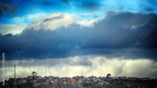 clouds over city quito ecuador with plain