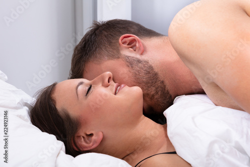 Man Kissing Woman On Bed