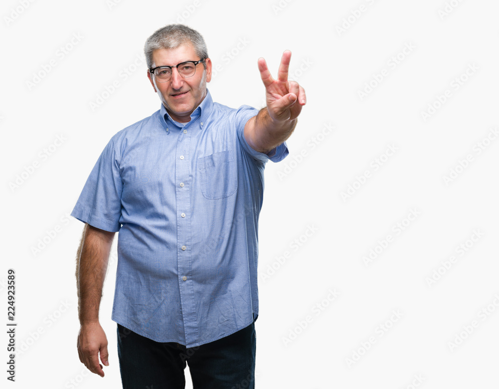 Handsome senior man wearing glasses over isolated background smiling with happy face winking at the camera doing victory sign. Number two. Handsome senior man wearing glasses over isolated background smiling with happy face winking at the camera doing victory sign. Number two.