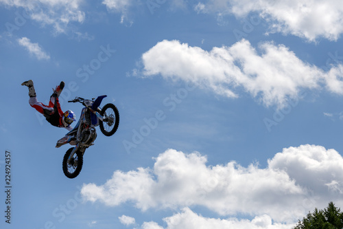 Sports, extreme, speed, adrenaline concept. Stylish biker jumping on his motorcycle and flying in the sky among the clouds.