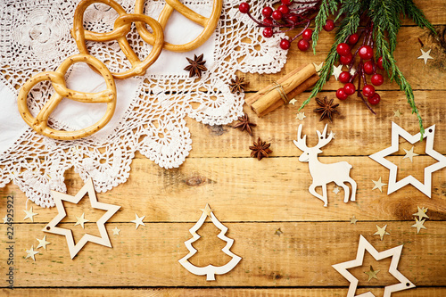 beautiful Christmas Eve background on an old wooden table with decorations and delicious pretzels photo