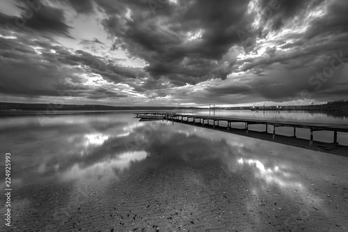 Stunning black and white long exposure seascape with clouds reflection.