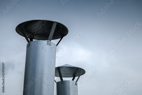 Two round steel chimneys over blue sky
