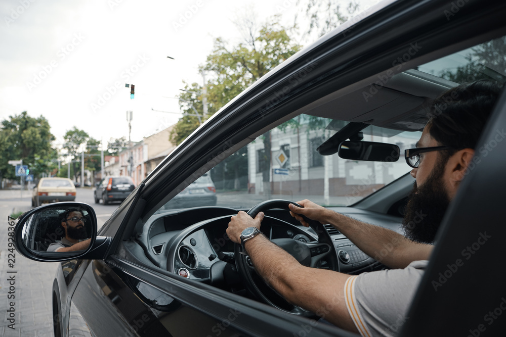 Modern casual bearded man driving a car Modern casual bearded man driving a car