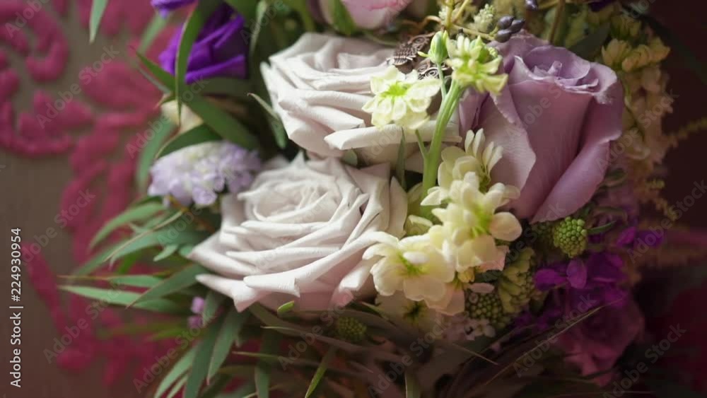 Bridal bouquet with pink, white and violet roses at pink sofa chair indoors Bridal bouquet with pink, white and violet roses at pink sofa chair indoors