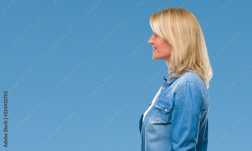 Middle age blonde woman over isolated background looking to side, relax profile pose with natural face with confident smile. Middle age blonde woman over isolated background looking to side, relax profile pose with natural face with confident smile.