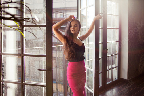 Beautiful young woman near a huge window.