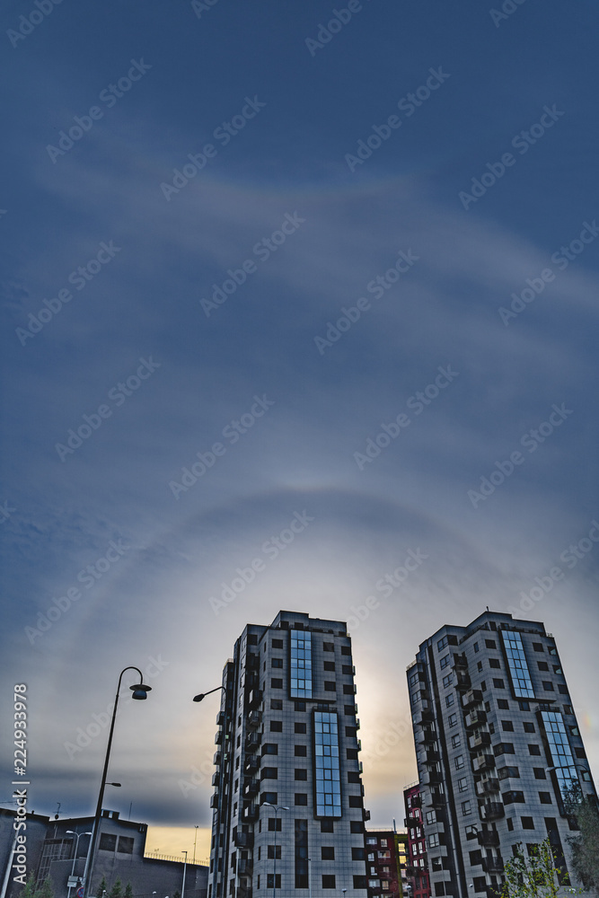 a Rainbow halo around the sun in blue evening sky