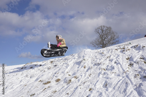 Mutiges Mädchen beim Rodeln, Winterfreuden, Schlittenspass photo