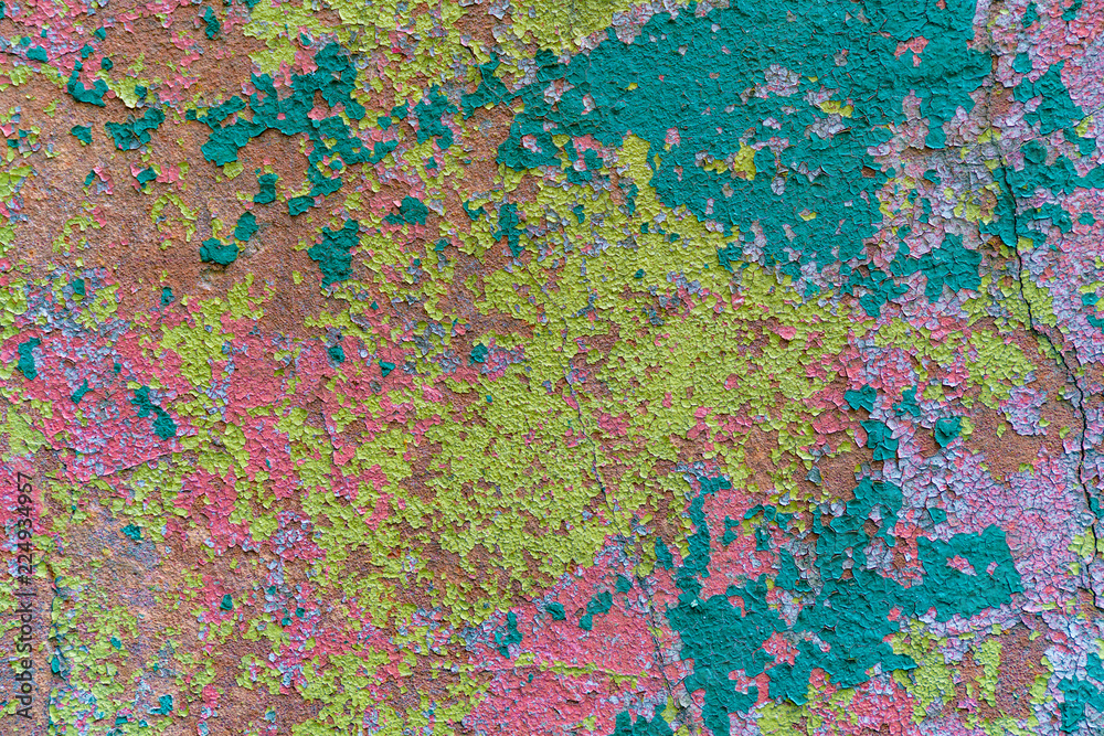 an old painted wall with pealing paint, yellow, blue, pink spots