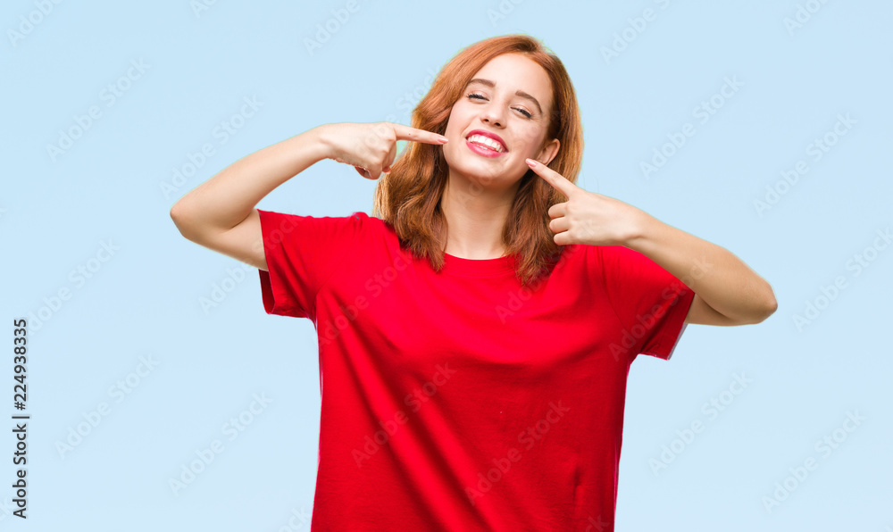 Young beautiful woman over isolated background smiling confident showing and pointing with fingers teeth and mouth. Health concept. Young beautiful woman over isolated background smiling confident showing and pointing with fingers teeth and mouth. Health concept.