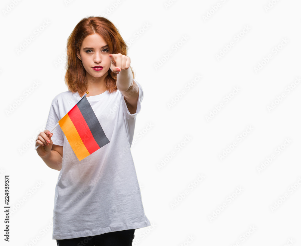 Young beautiful woman holding flag of germany over isolated background pointing with finger to the camera and to you, hand sign, positive and confident gesture from the front Young beautiful woman holding flag of germany over isolated background pointing with finger to the camera and to you, hand sign, positive and confident gesture from the front