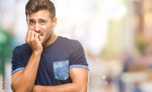 Young handsome man over isolated background looking stressed and nervous with hands on mouth biting nails. Anxiety problem.