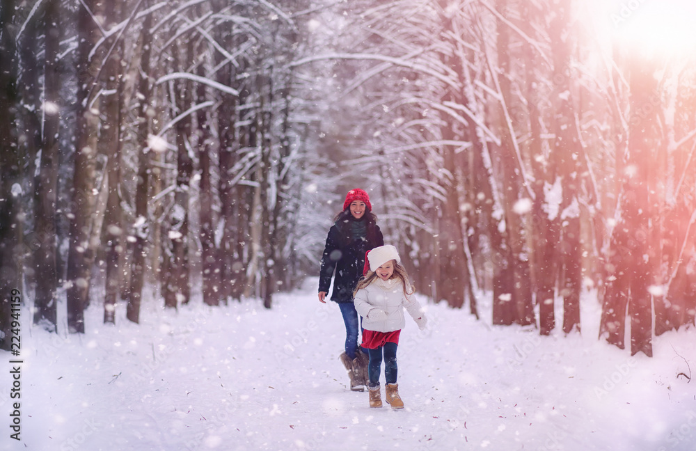 A winter fairy tale, a young mother and her daughter ride a sled