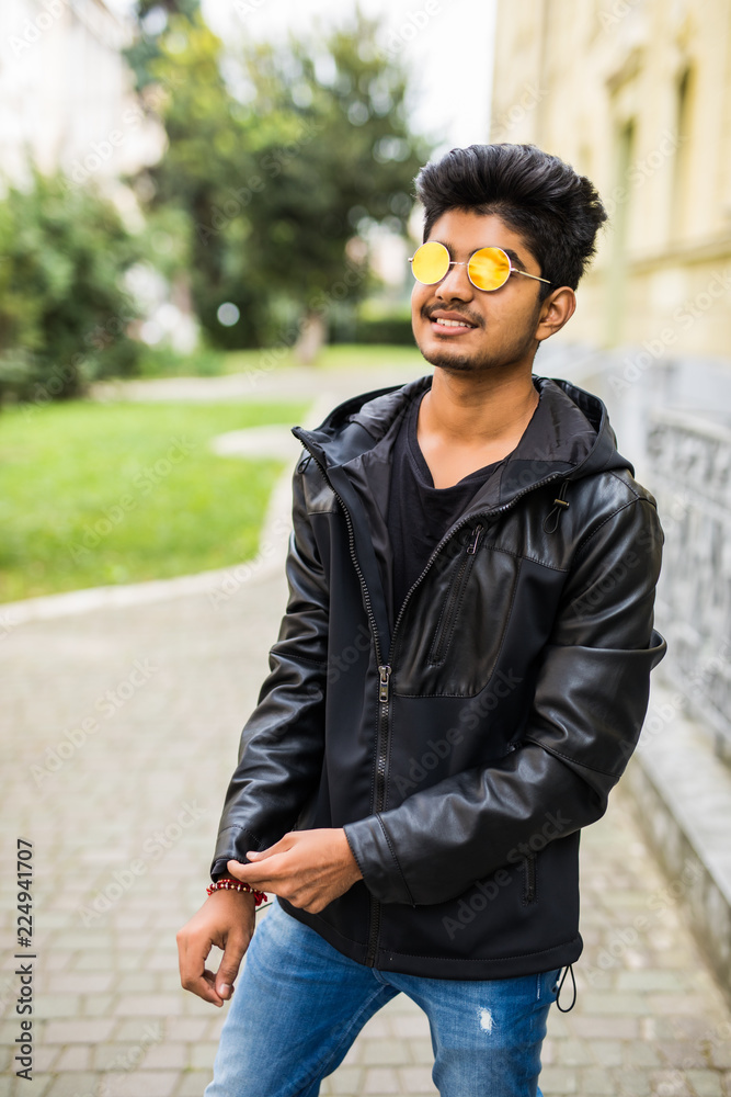 Young indian man walking on the city summer street Young indian man walking on the city summer street