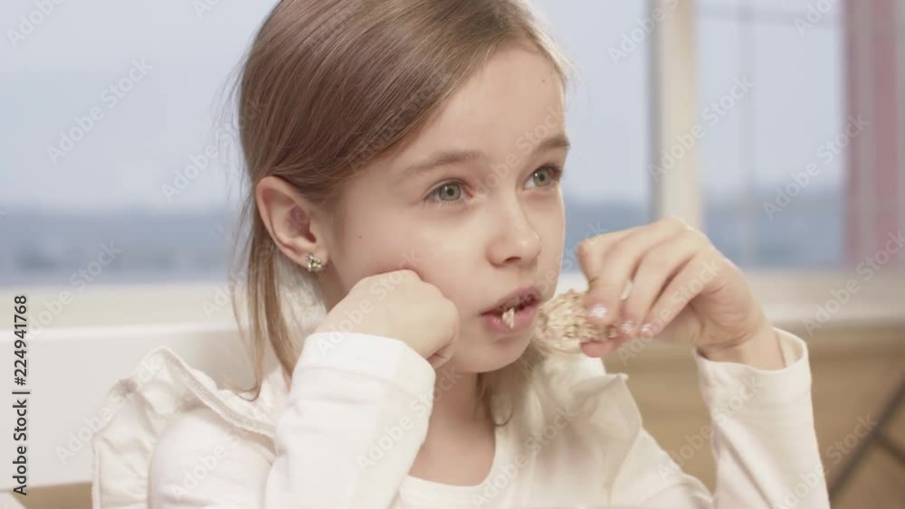 Little Girl Eats Rice Bread During A Family Dinner