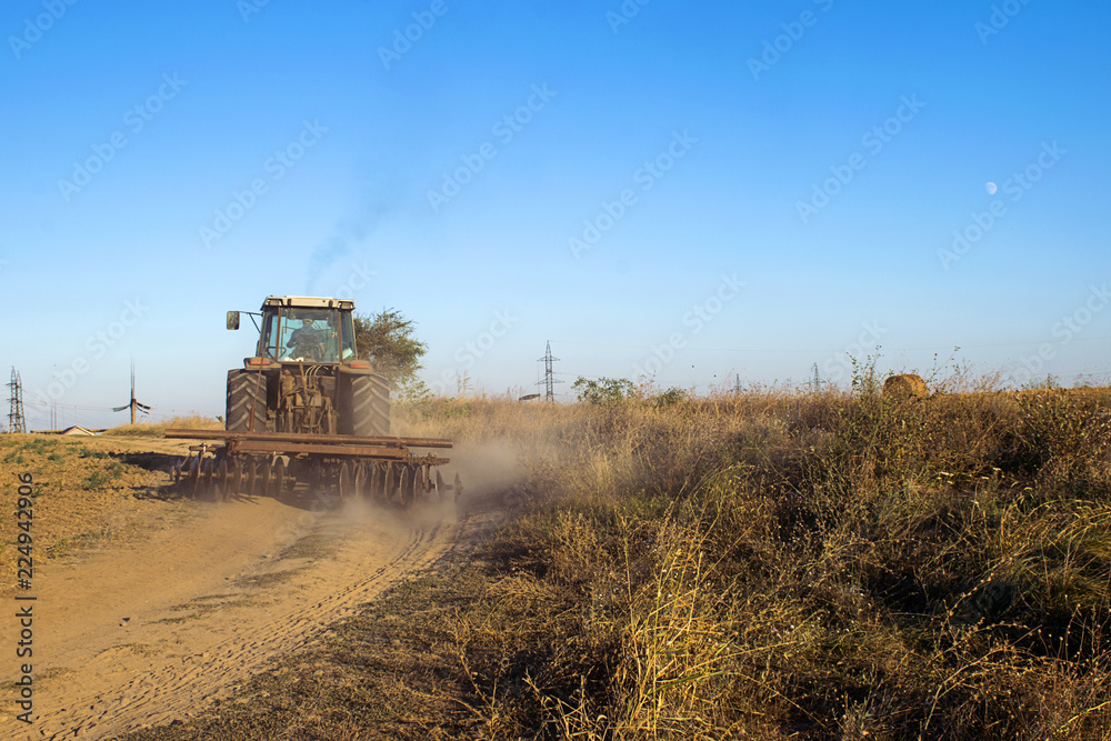 Fototapeta premium Moving Tractor on a dirt road