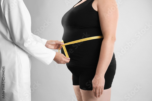 Εκτύπωση καμβά Doctor measuring fat woman's waist on grey background