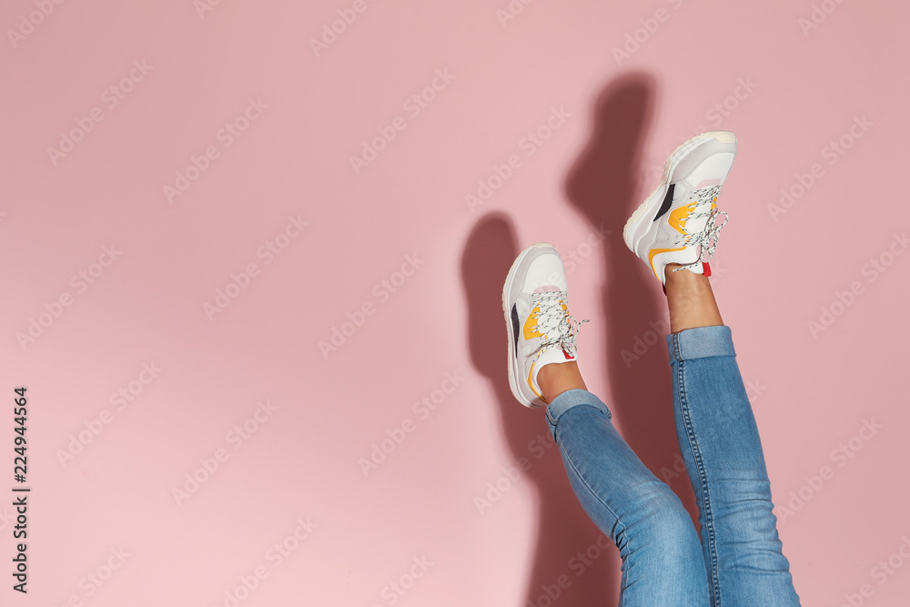 Woman in stylish sneakers near color wall, closeup. Space for text - obrazy, fototapety, plakaty 
