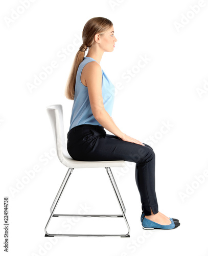 Woman sitting on chair against white background. Posture concept photo