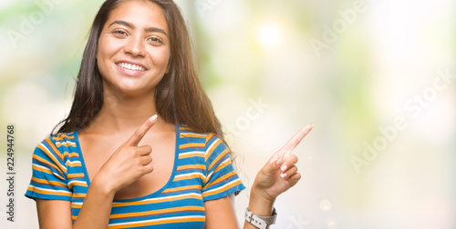 Young beautiful arab woman over isolated background smiling and looking at the camera pointing with two hands and fingers to the side.