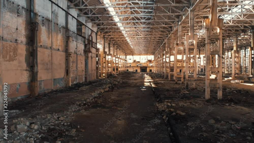 Abandoned and haunted industrial creepy warehouse inside, old ruined grunge factory building, shot from drone flying inside, toned