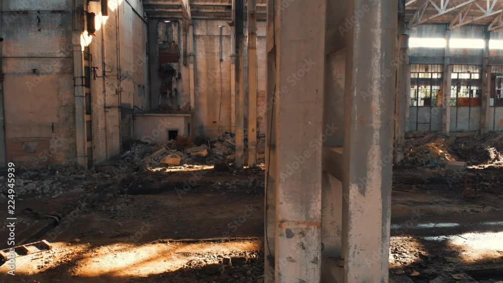 Abandoned and haunted industrial creepy warehouse inside, old ruined grunge factory building, shot from drone flying inside, toned