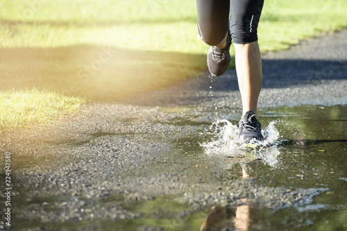 running through a puddle of water, splashes and drops around feet
