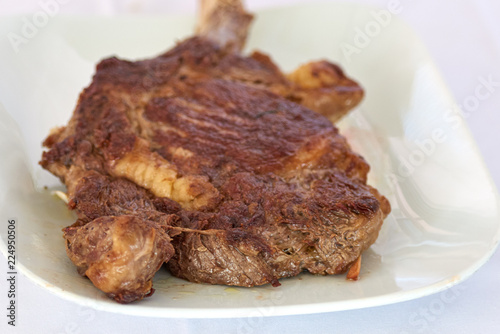 Beautifully seared tomahawk steak on the plate, medium rare to rare.Barbecue Kobe Tomahawk Steak