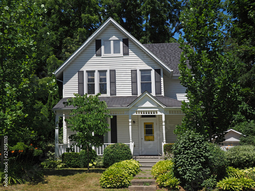 Canvas-taulu White clapboard house with gable surrounded by trees