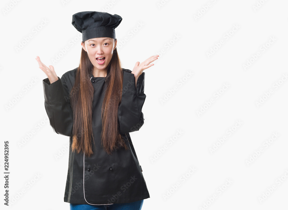 Young Chinese woman over isolated background wearing chef uniform celebrating crazy and amazed for success with arms raised and open eyes screaming excited. Winner concept Young Chinese woman over isolated background wearing chef uniform celebrating crazy and amazed for success with arms raised and open eyes screaming excited. Winner concept