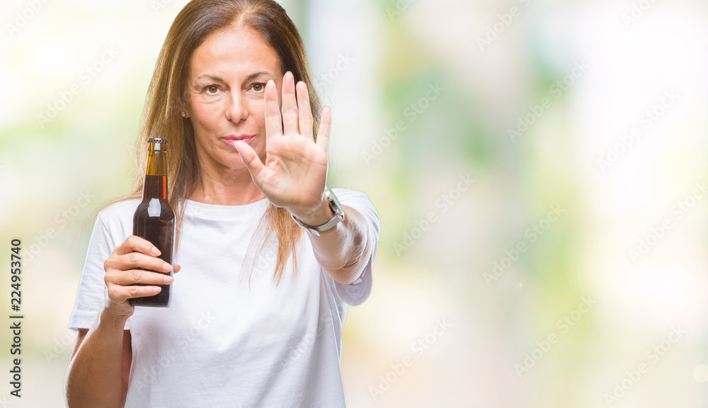 Middle age hispanic woman drinking beer over isolated background with open hand doing stop sign with serious and confident expression, defense gesture