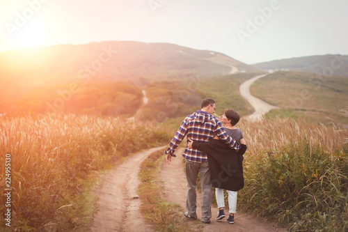 Loving attractive middle-aged couple walking away on the road.