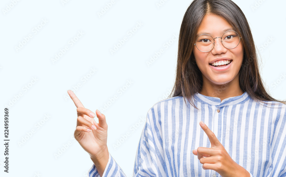 Young asian woman over isolated background smiling and looking at the camera pointing with two hands and fingers to the side. Young asian woman over isolated background smiling and looking at the camera pointing with two hands and fingers to the side.
