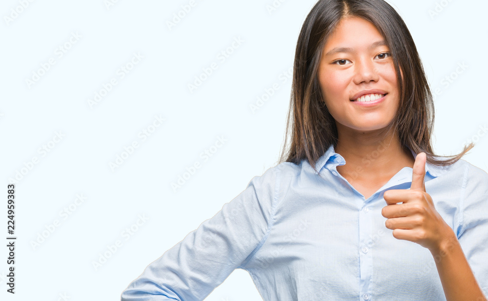 Young asian business woman over isolated background doing happy thumbs up gesture with hand. Approving expression looking at the camera with showing success. Young asian business woman over isolated background doing happy thumbs up gesture with hand. Approving expression looking at the camera with showing success.