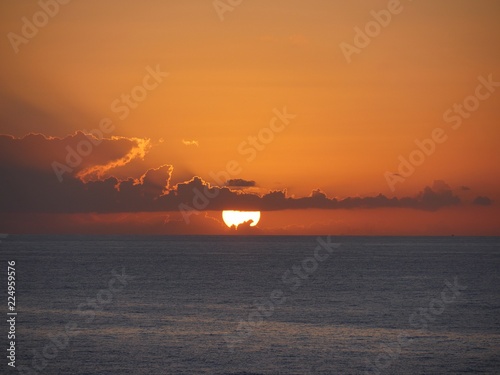 Sunset over the Caribbean Clouds hide part of the setting sun in the Caribbean ocean.