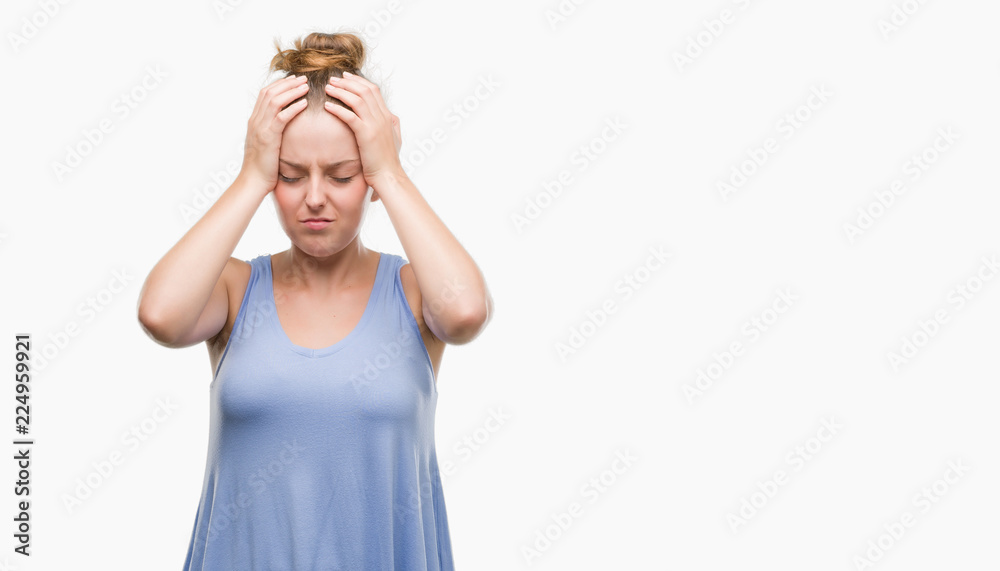 Young blonde woman suffering from headache desperate and stressed because pain and migraine. Hands on head.